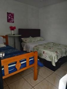 a bedroom with two beds and a table in it at LUGAR DE DESCANSO in Ica