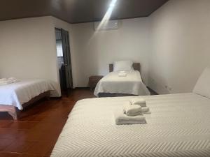 1 dormitorio con 2 camas y toallas. en Hotel y Restaurante El Páramo, en San Rafael Norte