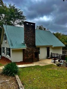 Crane Hill的住宿－Best Life Now Cottage，一座带砖烟 ⁇ 的绿色屋顶的房子