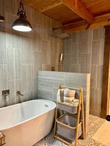 a bathroom with a bath tub and a chair at Best Life Now Cottage in Crane Hill