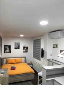 ein Schlafzimmer mit einem gelben Bett in einem Zimmer in der Unterkunft Apartman Park Kragujevac in Kragujevac