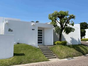 a white house with a tree in front of it at Casa Golondrina in Xochitepec