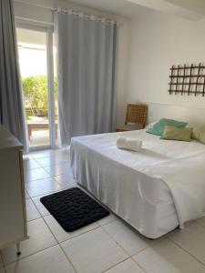 um quarto com uma cama branca e um tapete preto no chão em Apartamento Master VIP com 3 suítes noTree Bies Resort em Subaúma