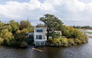 a house on an island in the water at Lakehouse Inchiquin in Droíchead an Chláir