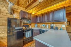 een keuken met houten kasten en een koelkast bij Mountain View Log Cabin in Carroll