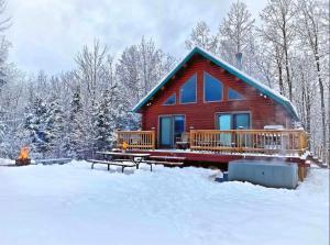 een blokhut met een terras in de sneeuw bij Mountain View Log Cabin in Carroll