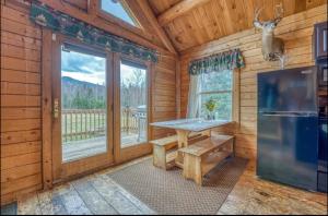 a dining room with a table and a large window at Mountain View Log Cabin in Carroll