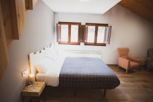 um quarto com uma cama, uma cadeira e janelas em Coll de Port em Tuixen