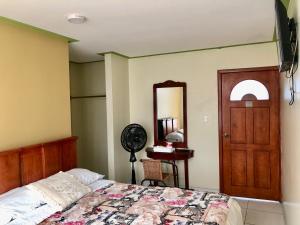 a bedroom with a bed and a mirror and a door at HOTEL CARIAMANGA in Santo Domingo de los Colorados