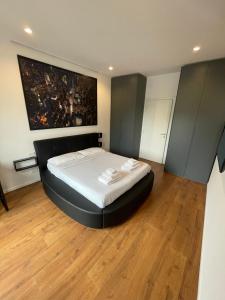 a bedroom with a large bed with a black headboard at Savoia Luxury Apartment in Milan