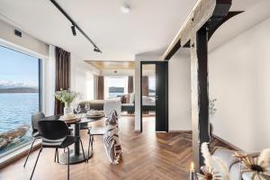 a dining room and living room with a view of the water at Steam Pier in Kvaløya