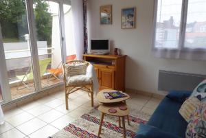 a living room with a blue couch and a tv at Studio in Pornic