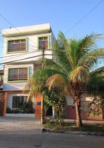 ein Gebäude mit zwei Palmen davor in der Unterkunft 203 RV Apartments Iquitos-Apartamento con dos habitaciones in Iquitos