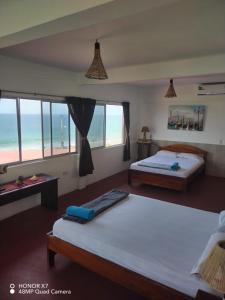 a bedroom with two beds and a view of the ocean at Hospedaje Algarrobo Machalilla in Machalilla