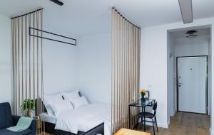 a bedroom with a bed and a chair and a table at Vibrant Studio in Timişoara