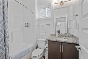 a white bathroom with a toilet and a sink at Charming Duplex Retreat in Old Town Manchester, VA in Richmond +46 photos