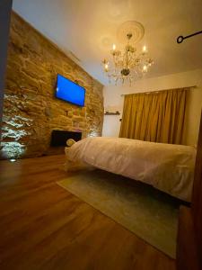 a bedroom with a bed and a tv on a stone wall at Hector’s luxurious apartment in Castle Donington