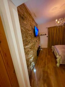 a room with a stone wall with a television on it at Hector’s luxurious apartment in Castle Donington