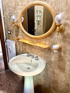 bagno con lavandino e specchio di LEONE VACANZE a Genova