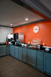 una cocina con armarios azules y una pared de color naranja en Howard Johnson by Wyndham Near Schlitterbahn, en New Braunfels