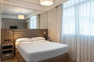 佛羅安那波里的住宿－藍樹高級弗洛里亞諾波利斯旅館，一间卧室设有一张大床和一个大镜子