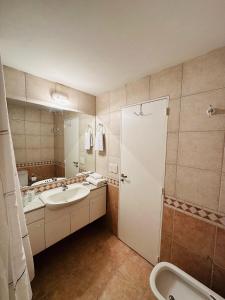 y baño con lavabo, aseo y espejo. en Apartamento Avenida del Libertador en Buenos Aires