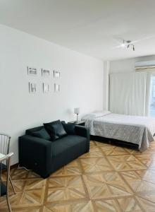 a living room with a bed and a couch at Apartamento Avenida del Libertador in Buenos Aires