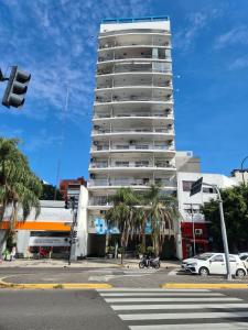 a tall white building with palm trees in front of it at Apartamento Avenida del Libertador in Buenos Aires
