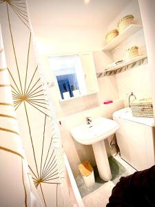 a white bathroom with a sink and a toilet at L’Exotique in Menton