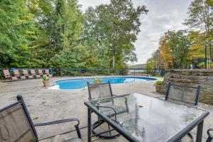 un patio con mesa y sillas y una piscina en Milton Hidden Gem with Pool, Hot Tub and Fireplace!, en Milton