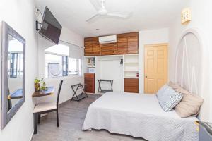 1 dormitorio con 1 cama, escritorio y TV en Hotel Bahia Huatulco, en Santa Cruz Huatulco