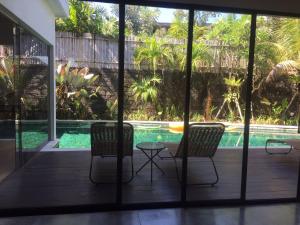 a patio with two chairs and a swimming pool at The Kesari Luxury Villa in Sanur