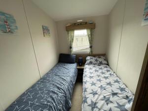 a small bedroom with two beds and a window at B3 Sunny Tides in Brixham