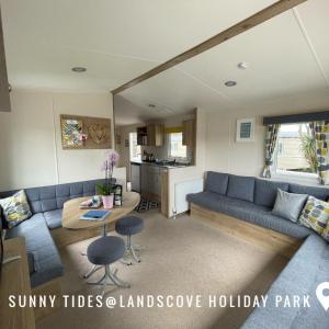 ein Wohnzimmer mit einem blauen Sofa und einem Tisch in der Unterkunft B3 Sunny Tides in Brixham