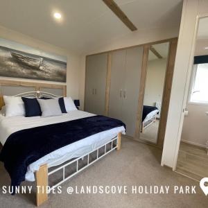 a bedroom with a large bed and a mirror at B3 Sunny Tides in Brixham