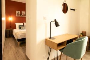 1 dormitorio con 1 cama, escritorio y 1 cama en Nîmes Centre - A 5 minutes des Arènes, en Nimes