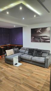 a living room with a couch and a wooden floor at ALAMO LUXURY APARTMENT in Playa del Ingles