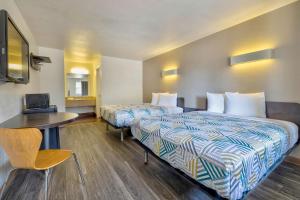 ein Hotelzimmer mit 2 Betten und einem Tisch in der Unterkunft Motel 6-Bryan, TX - College Station in Bryan