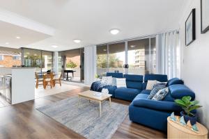 a living room with a blue couch and a table at Shores Unit 201 in Forster