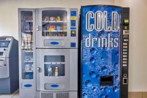 a cold drink refrigerator next to a soda machine at Motel 6-Bryan, TX - College Station in Bryan