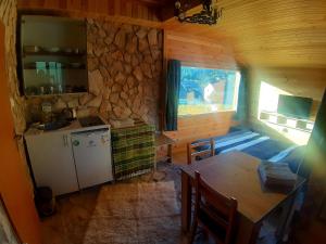 cocina con mesa y pared de piedra en Biljana Sweet Home, en Pale