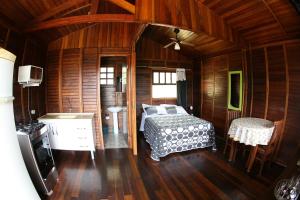 een slaapkamer met een bed in een houten kamer bij Chalé Heliconia in Juquitiba