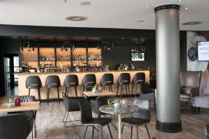 un bar con sillas y mesas en un restaurante en Dorint An den Westfalenhallen Dortmund, en Dortmund