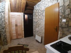 baño con pared de piedra y puerta de madera en Biljana Sweet Home, en Pale