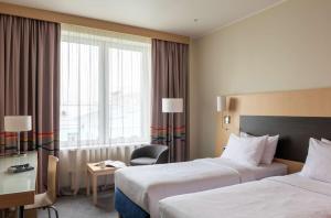 a hotel room with two beds and a window at Park Inn by Radisson Novosibirsk in Novosibirsk