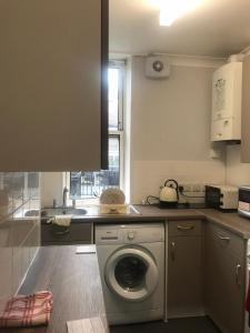 a kitchen with a washing machine and a sink at Double Room close to Central London- Females Only in London