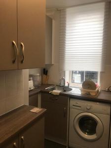 a kitchen with a washing machine and a window at Double Room close to Central London- Females Only in London