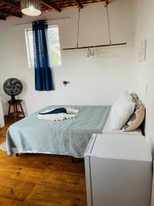a bedroom with a bed and a refrigerator at Quartinho Branco in Atins