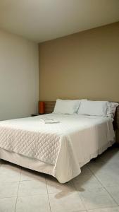 Un pat sau paturi într-o cameră la Pousada Colonial