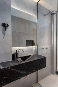 La salle de bains est pourvue d'un lavabo et d'un miroir. dans l'établissement Unhotel - Rio Exclusive Design Loft Copacabana Perto da Praia, à Rio de Janeiro